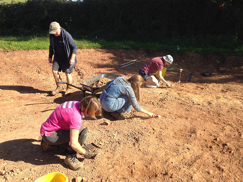 Three people digging carefully